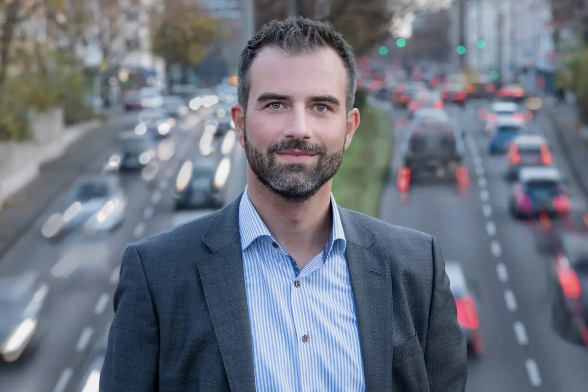 Businessportrait eines Mannes vor urbaner Kulisse mit Straßenverkehr – modernes Outdoor-Shooting in Köln, fotografiert von nonverbal | businessfotografie.